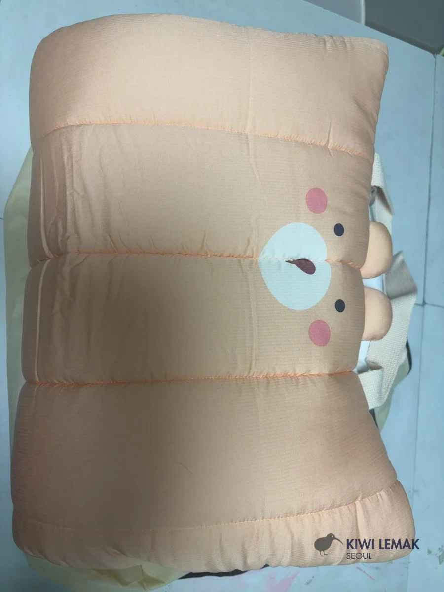 A Korean daycare nap bedding set folded up in its everyday storage state, with a bear-face applique