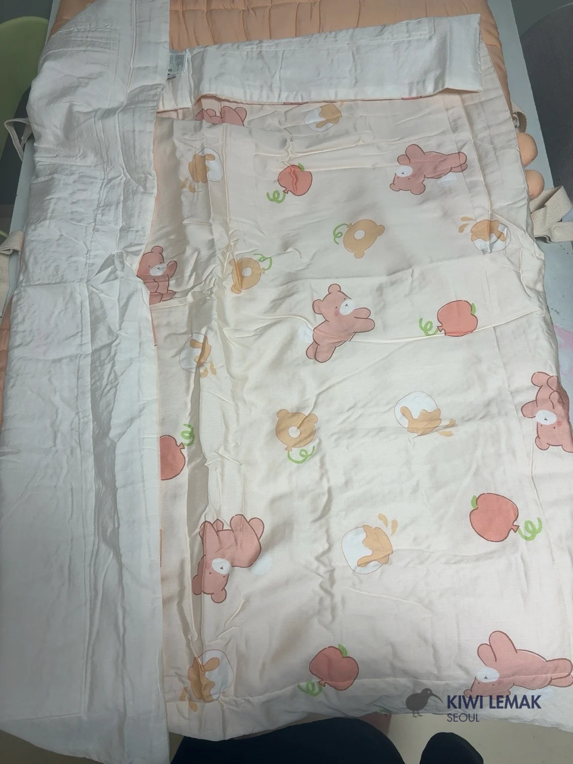 Close-up of the cover fabric pattern on a Korean daycare nap bedding set, showing the bear, apple, and donut print lining