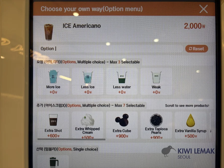 A coffee kiosk customization screen showing add-on options including extra vanilla syrup